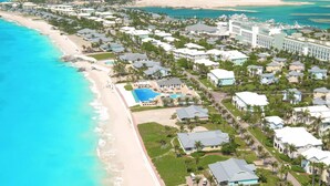 Luftaufnahme eines Küstenresorts mit Strandhäusern, einem zentralen Poolbereich und einer Marina.