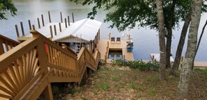 Un muelle de madera con techo metálico que conduce a una embarcación amarrada.