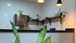 Une cuisine moderne avec des carreaux blancs, des étagères en bois et des luminaires suspendus.