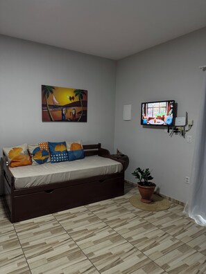 A bedroom with a bed, a painting, a television, and a potted plant. - Casa Solmar, 1 minute from Guriú Beach / ideal for kitesurfers. (Camocim)