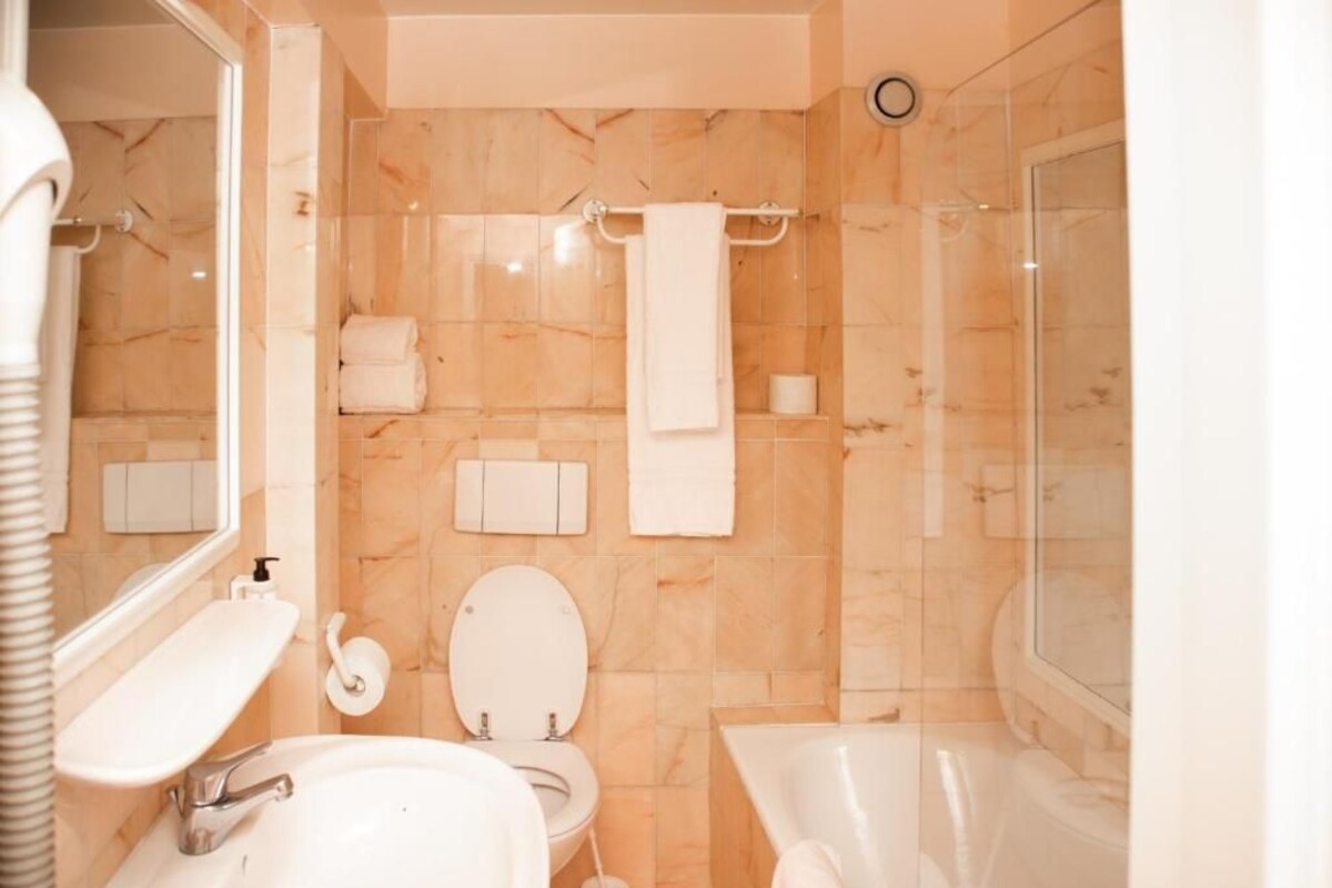A bathroom with a toilet, sink, and bathtub.