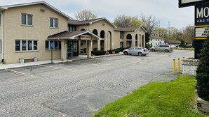Een motel receptie met een parkeerplaats en een bord voor La La Motel.