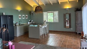 Een ruime keuken met een centraal eiland, een koelkast, en een eethoek met tafel en stoelen.