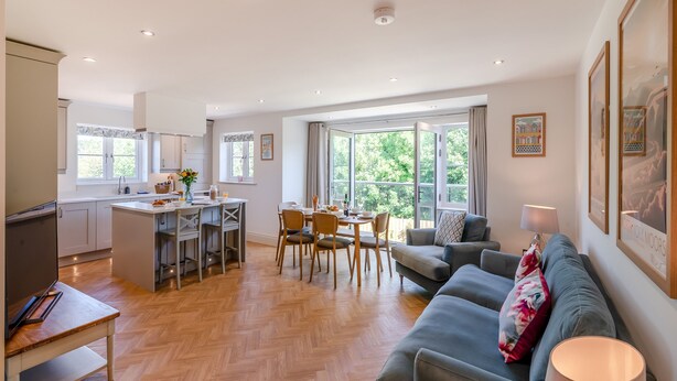 A spacious living area with a dining table, sofa, and kitchen.