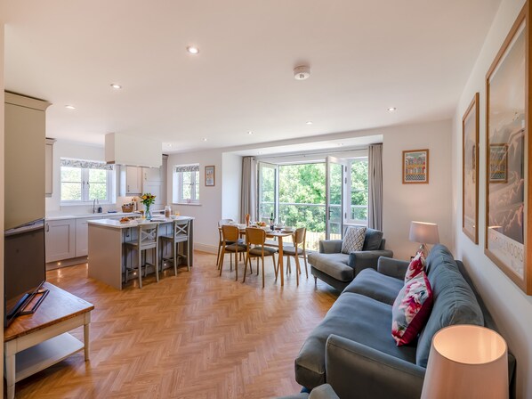 A spacious living area with a dining table, sofa, and kitchen.