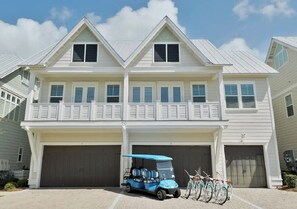 A two-story house with a garage, a covered porch, and a bicycle rack.