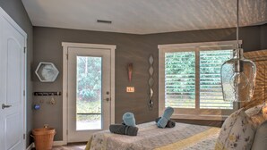 Une chambre à coucher avec un lit, une porte, une fenêtre et un luminaire suspendu.