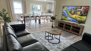 A modern living room with a leather sofa, a coffee table, and a TV mounted on the wall.