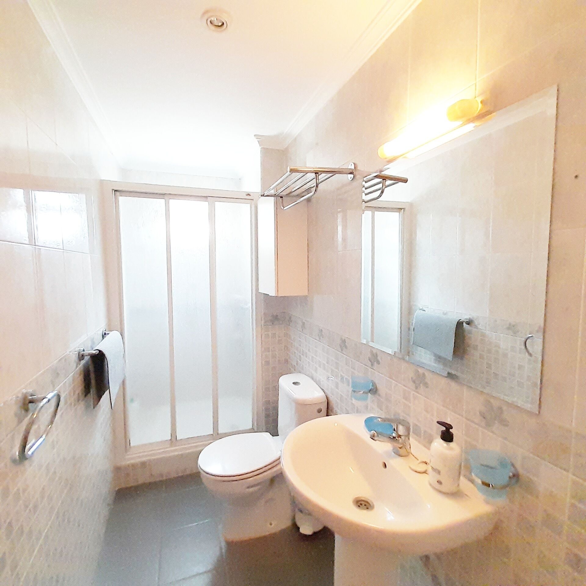 A bathroom with a toilet, sink, and shower area.