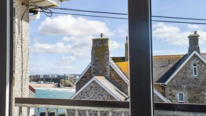 A stone building with a view of the sea and a bridge in the background. - Apartment 15 Harvest Moon (Newquay)