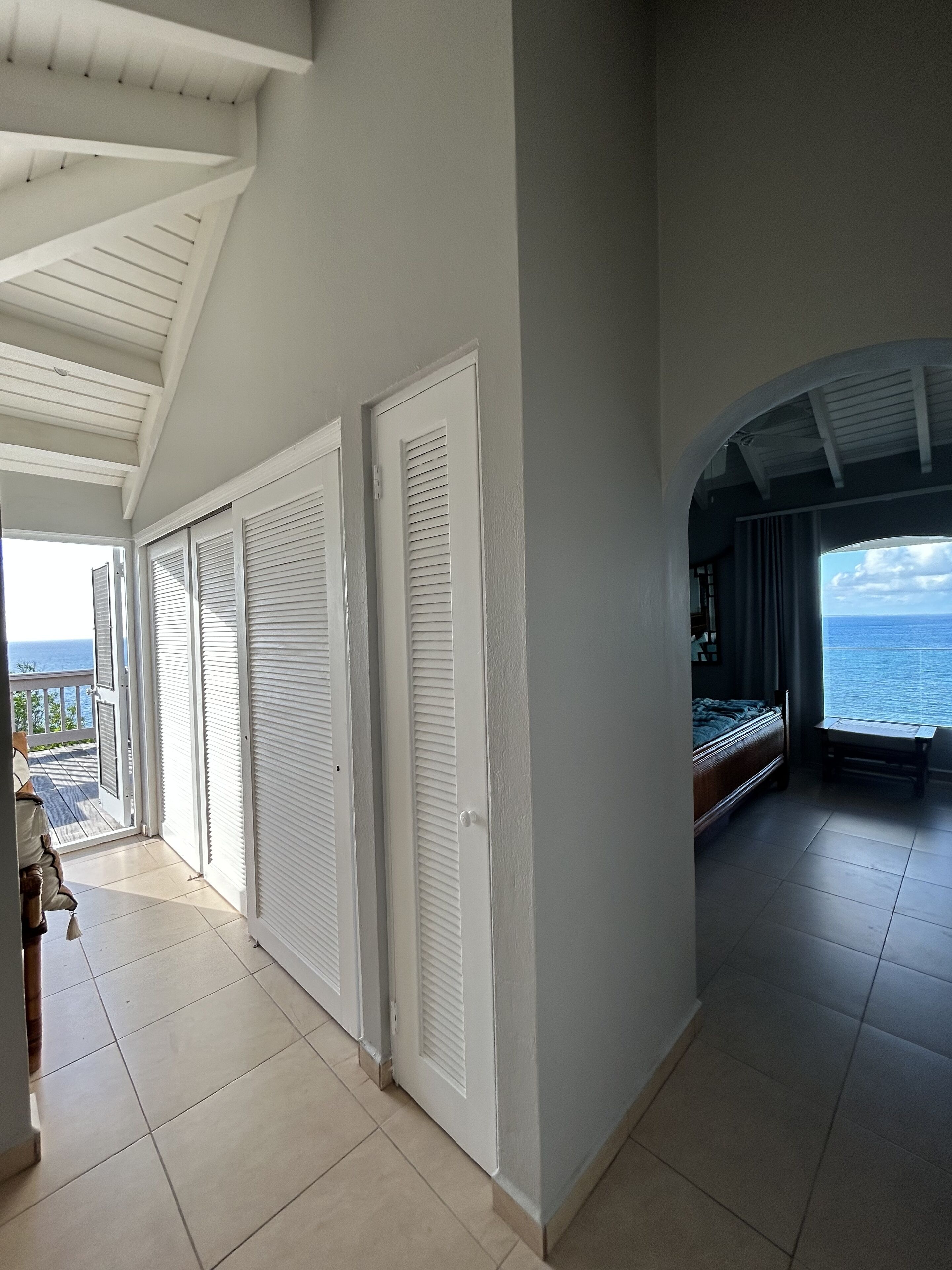 Amplia habitación con vista al mar, un balcón y una cama con vistas.