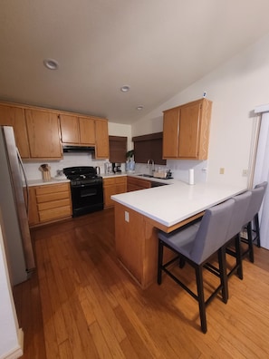 Une cuisine moderne avec des meubles en bois, un îlot central et une cuisinière intégrée.