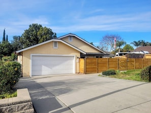 Une maison de plain-pied avec un garage, une clôture en bois et une pelouse bien entretenue.
