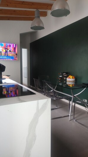 Une salle de conférence moderne, dotée d’une table en marbre, de chaises transparentes et d’un mur d’accent vert.