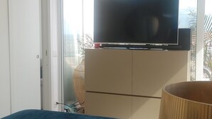 A bedroom with a bed, a television on a cabinet, a window, and an air conditioning unit. - PENTHOUSE ON CATANIA HARBOR AND VOLCANO VIEW A FEW STEPS FROM CATHEDRAL (Catania)