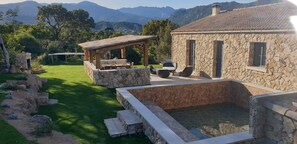 A stone building with a patio and a swimming pool.