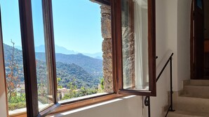Una escala amb vista a un paisatge de muntanyes a través de grans finestres.