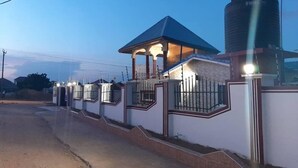 Un área residencial cerrada con una casa que tiene un porche cubierto y un tanque de agua.