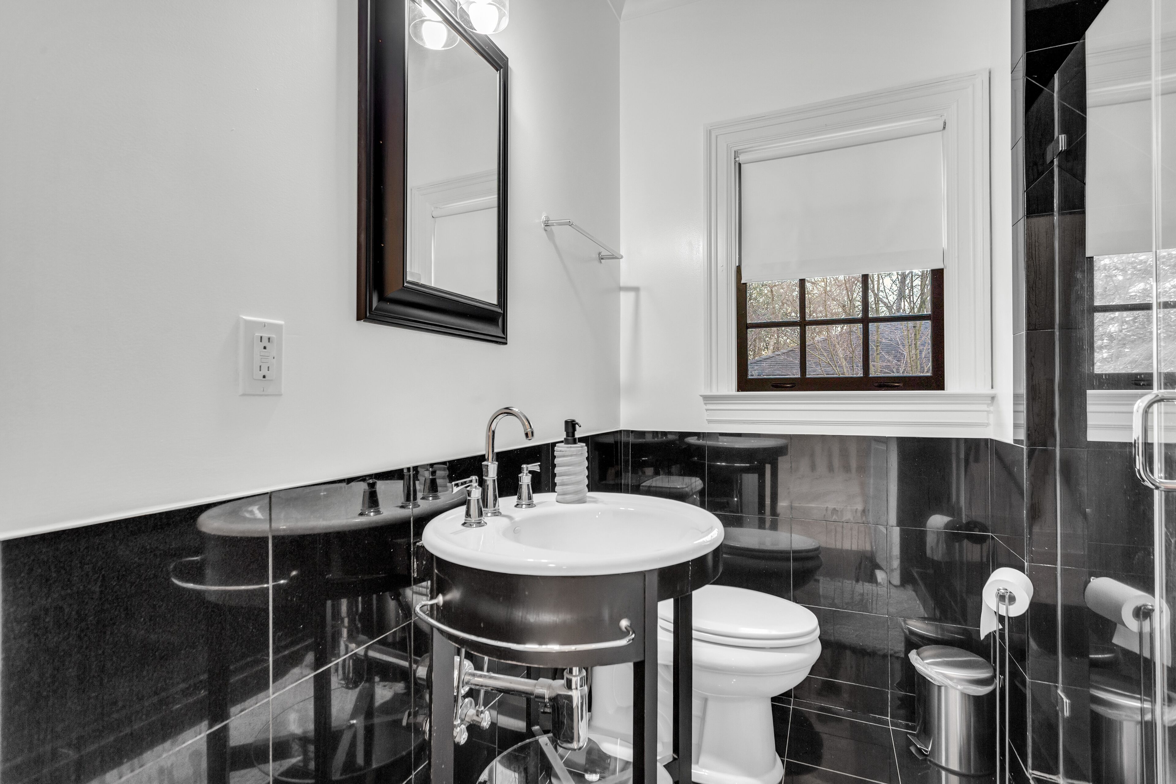 Une salle de bain moderne avec un grand lavabo, des toilettes et un miroir.