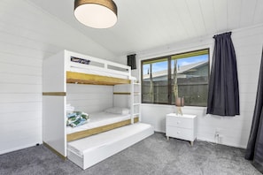 A bunk bed room with a window, a bedside table, and a lamp. - Be Rude Not To - Walk to Redwoods, Sleeps 7 (Rotorua)