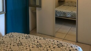 Ein Schlafzimmer mit einem Bett, einem Spiegel und einer Deckenleuchte.
