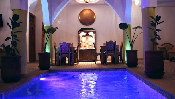 A pool area with a seating arrangement and a decorative fountain. - Riad La Petite Rose (Marrakech)