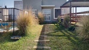 A modern house with a swimming pool, a covered patio, and a pathway leading to the entrance. - El Remanso (San José)