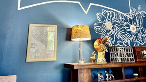 Una pared con un letrero que dice 'POST ALLEY', un mapa enmarcado, una lámpara y objetos decorativos.