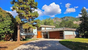 A two-story house with a garage, surrounded by trees and a mountain in the background. - Beautiful home just outside of Ogden Canyon (Ogden)