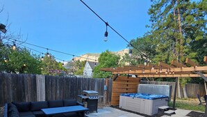 A backyard with a wooden pergola, outdoor seating, a hot tub, and a barbecue grill. - Beautiful home just outside of Ogden Canyon (Ogden)