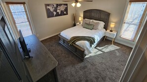 A bedroom with a bed, a ceiling fan, a world map on the wall, and a desk with a lamp. - Beautiful home just outside of Ogden Canyon (Ogden)