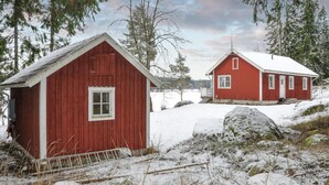 Two red wooden buildings with white trim, surrounded by snow-covered ground and trees. - Gorgeous home in Kristinehamn (Kristinehamn)