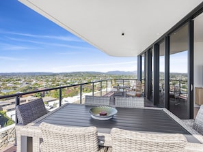 Enjoy the view from this balcony with a table and chairs, perfect for relaxing.