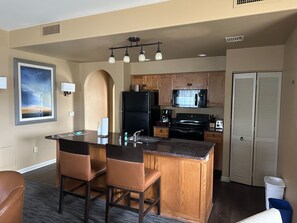 Enjoy cooking in this well-equipped kitchen with a central island, sink, stove, refrigerator, microwave, and coffee maker.