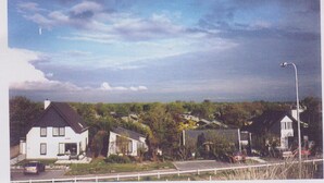 A residential area with houses, a road, and a streetlight.