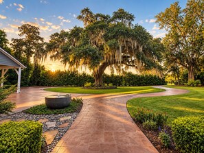 A landscaped garden with a curved pathway, a gazebo, and a large tree with hanging moss. - Waterfront w/ Pool & Hot Tub - 10 Min to Downtown (Savannah)