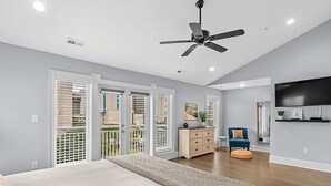 A bedroom with a large bed, a ceiling fan, and a balcony with sliding doors. - Luxe 4 Story Townhouse w/Elevator, Garage (Myrtle Beach)