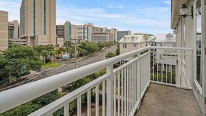 A balcony with a view of a cityscape, including buildings and a road. - Luxe 4 Story Townhouse w/Elevator, Garage (Myrtle Beach)
