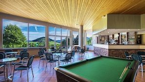 A pool table in a room with large windows, a bar area, and outdoor views. - L'ESCANDILLE Village Vacances (Autrans-Meaudre-en-Vercors)