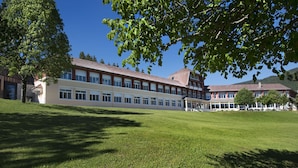 A large building with multiple windows and a covered outdoor area. - L'ESCANDILLE Village Vacances (Autrans-Meaudre-en-Vercors)