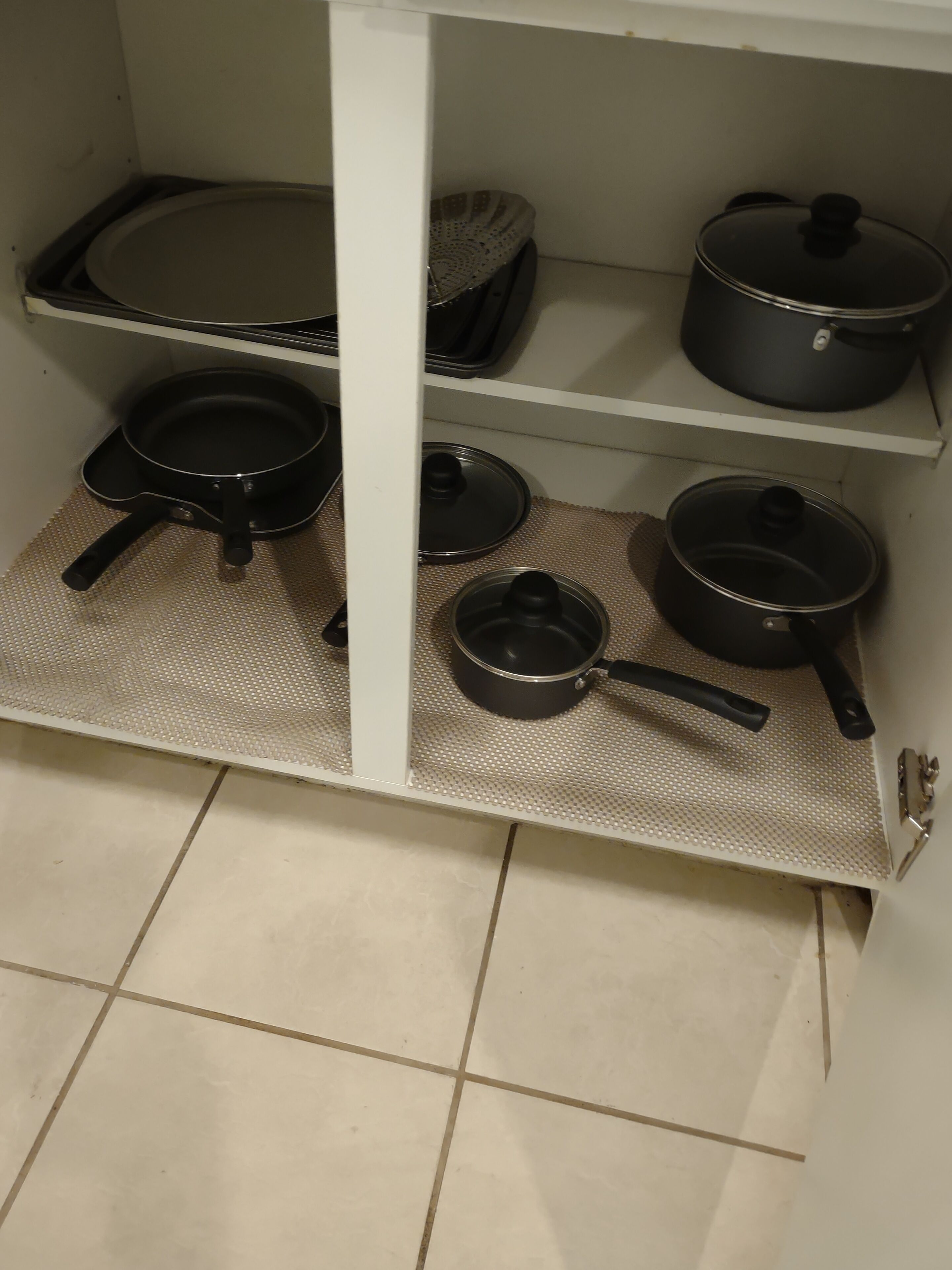 Uma cozinha com uma estante de metal para panelas e frigideiras.