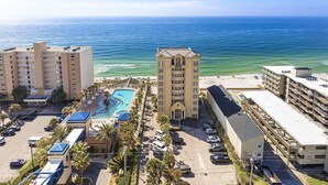 A hotel with a pool, parking, and a view of the ocean. - Crystal Tower Unit 1508 | Snowbird Friendly | Indoor, Outdoor Pools, Hot Tub, Sauna, Gym (Gulf Shores)