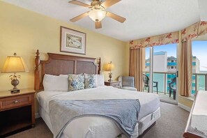 A hotel room with a bed, a ceiling fan, a balcony with a view, and a framed picture on the wall. - Malibu Pointe Beach Club 606 (North Myrtle Beach)