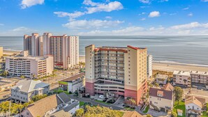 Ein Küstenhotel mit mehreren Hochhäusern, einer Tiefgarage und Blick auf den Strand.