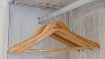Perchas de madera con un logotipo en una barra de metal.