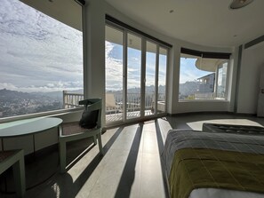 A spacious balcony with a view of a cityscape and mountains.