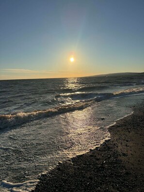 Une plage avec des vagues et un ciel dégagé.
