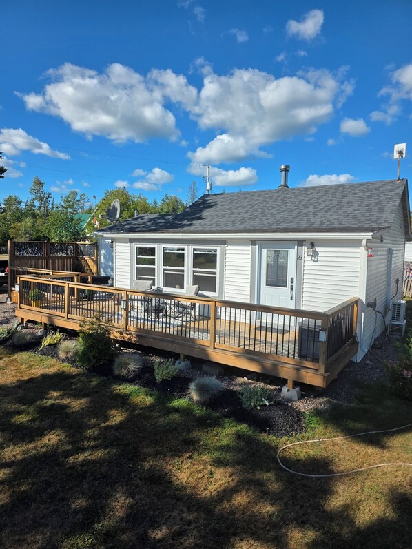 Une maison de plain-pied avec une terrasse, une antenne parabolique et une cheminée.