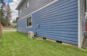 Une maison avec un revêtement extérieur bleu, un petit garage attenant et une pelouse bien entretenue.