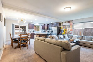 A spacious living area with a sofa, dining table, and chairs.